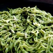 spaghetti in spinach sauce sunflowder seeds on top 