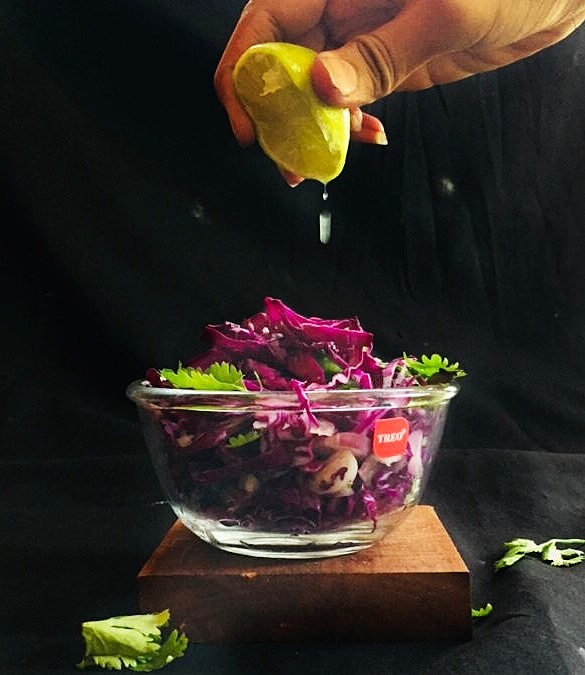 Healthy purple salad representing purple cabbage/lettuce, onions, squeeze of lemon, parsley's.